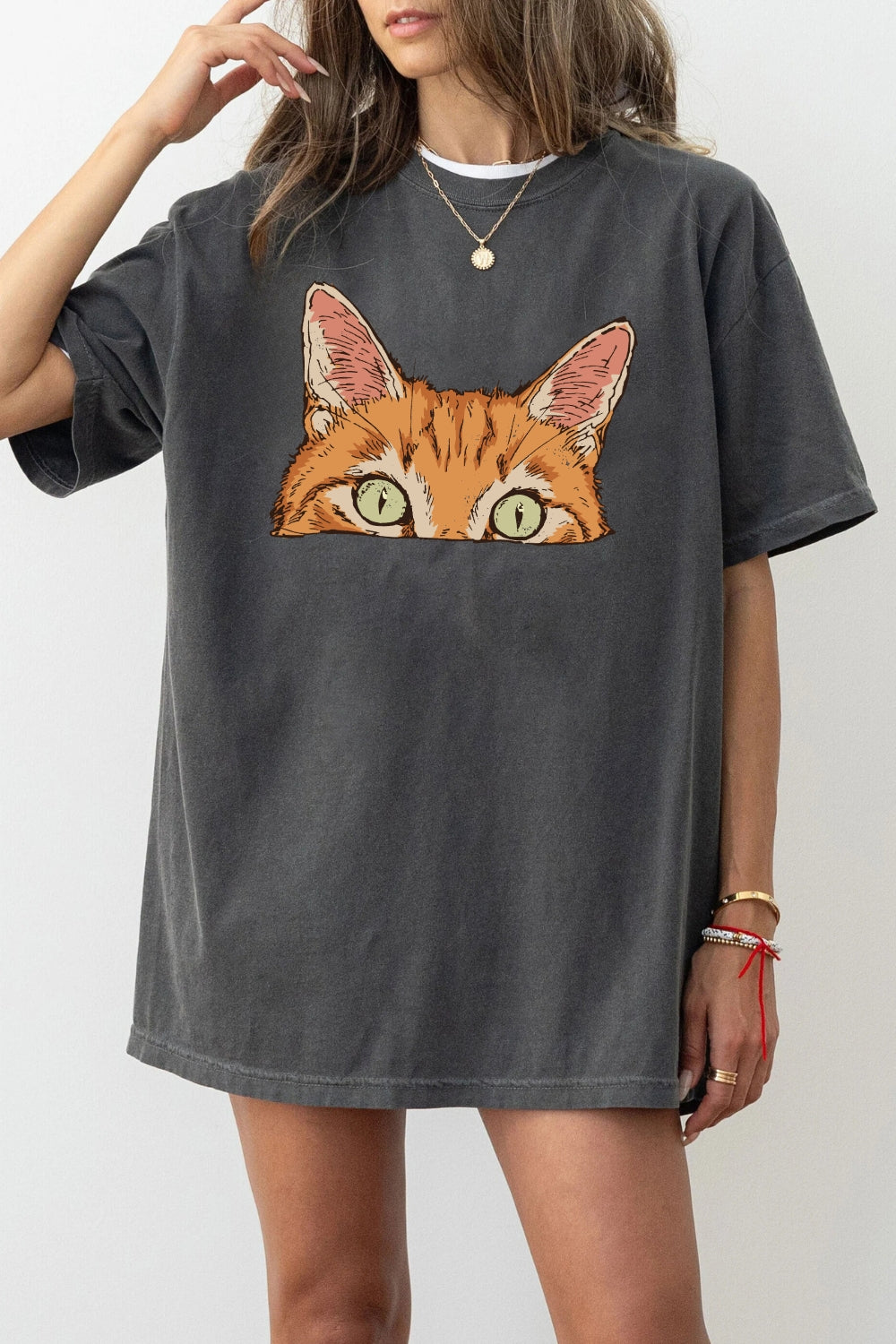 Curious orange tabby cat peeking tee
