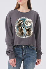Raccoons gather around the moon crop sweatshirt